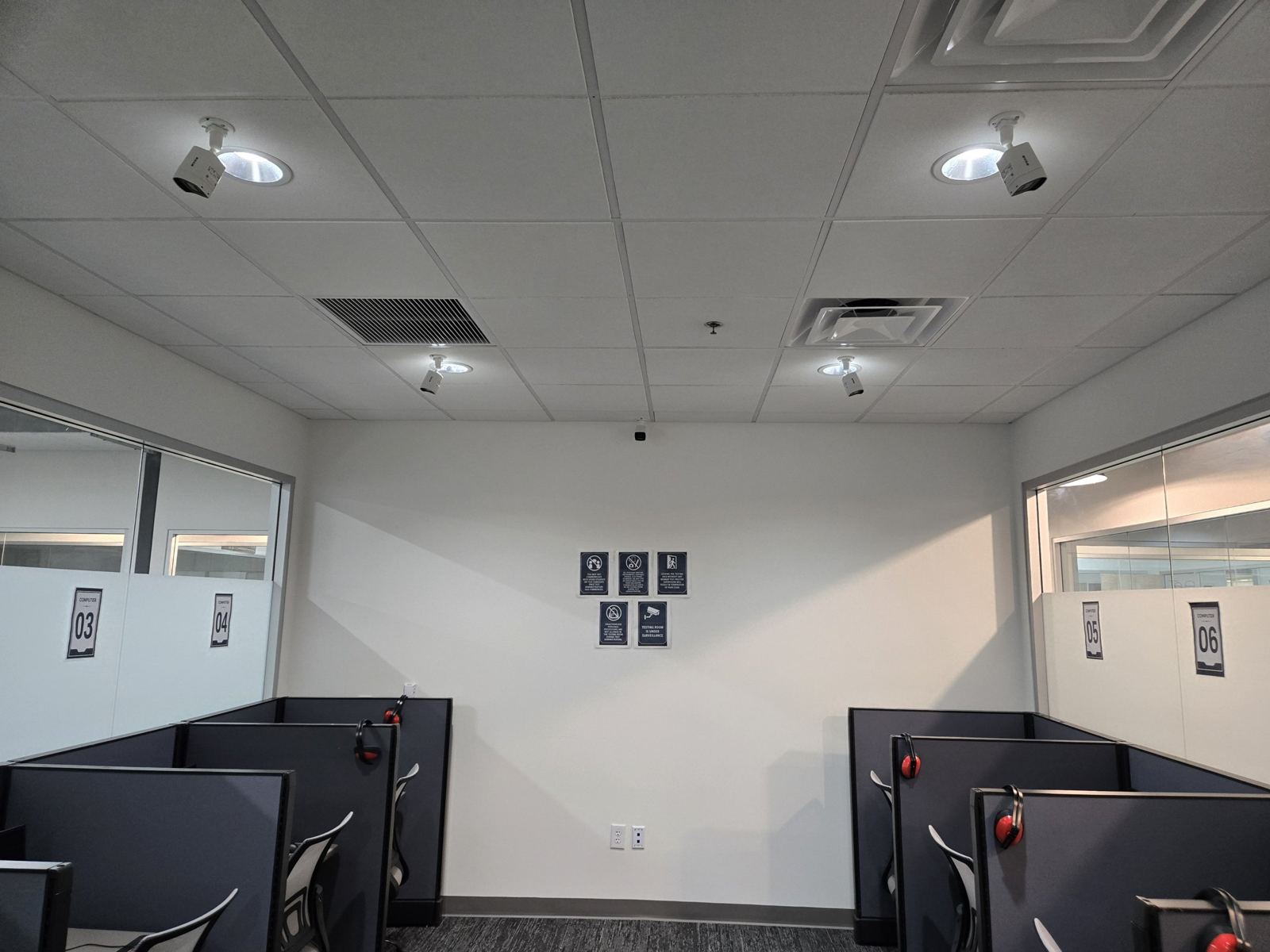 Real office installation with ceiling-mounted security cameras above workstations